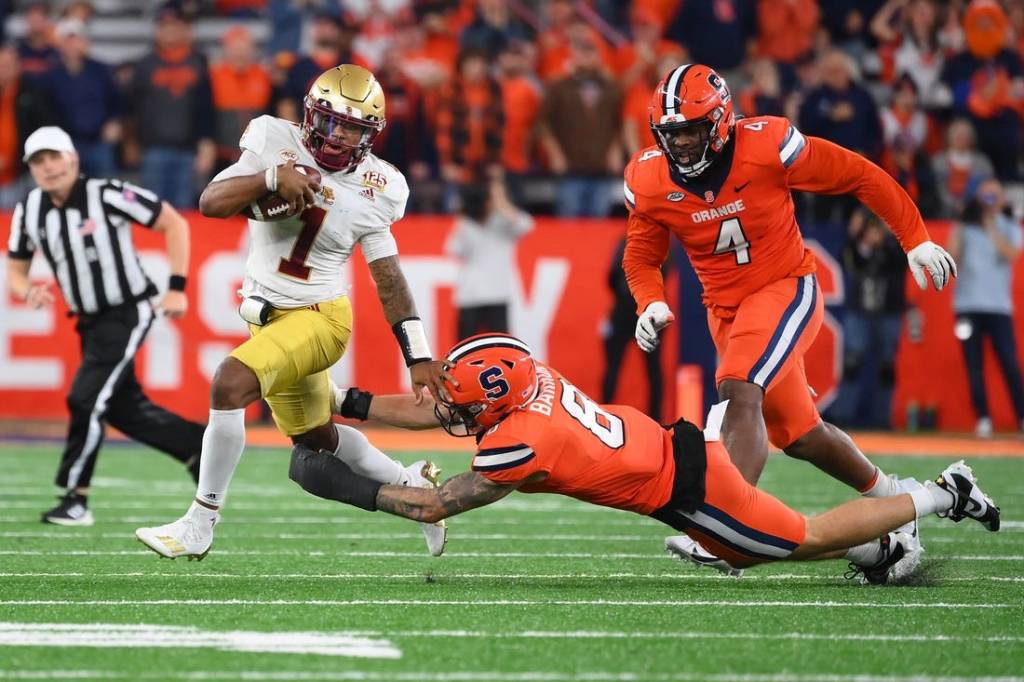 Nov 3, 2023; Syracuse, New York, USA; Boston College Eagles quarterback Thomas Castellanos (1) runs with the ball as Syracuse Orange defensive lineman Caleb Okechukwu (4) and defensive back Justin Barron (8) try to make the tackle during the second half at the JMA Wireless Dome. Mandatory Credit: Rich Barnes-USA TODAY Sports