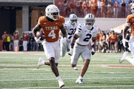 Nov 4, 2023; Austin, Texas, USA; Texas Longhorns running back CJ Baxter (4) runs for a touchdown while being chased by Kansas State Wildcats defensive back Kobe Savage (2) during the first half at Darrell K Royal-Texas Memorial Stadium. Mandatory Credit: Scott Wachter-USA TODAY Sports