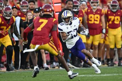Nov 4, 2023; Los Angeles, California, USA; Washington Huskies running back Tybo Rogers (20) carries the ball against USC Trojans safety Calen Bullock (7) during the second quarter at United Airlines Field at Los Angeles Memorial Coliseum. Mandatory Credit: Jonathan Hui-USA TODAY Sports