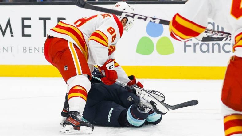 Nov 4, 2023; Seattle, Washington, USA; Calgary Flames left wing Andrew Mangiapane (88) cross-checks Seattle Kraken left wing Jared McCann (19) during the first period at Climate Pledge Arena. Mangiapane was given a major penalty for the play with intent to injure and ejected from the game. Mandatory Credit: Joe Nicholson-USA TODAY Sports