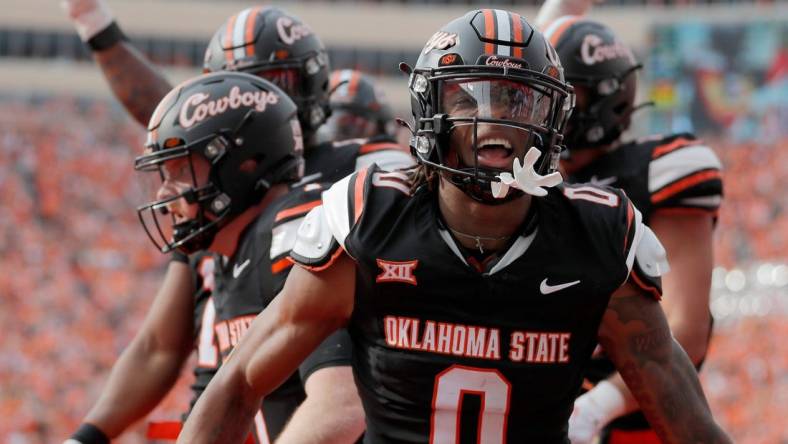 Oklahoma State's Ollie Gordon II (0) celebrates a Alan Bowman (7) touchdown in the first half during a Bedlam college football game between the Oklahoma State University Cowboys (OSU) and the University of Oklahoma Sooners (OU) at Boone Pickens Stadium in Stillwater, Okla., Saturday, Nov. 4, 2023.