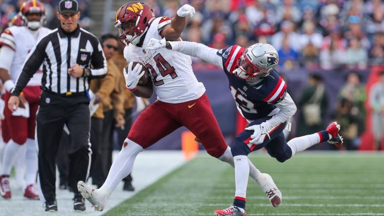 Nov 5, 2023; Foxborough, Massachusetts, USA; New England Patriots cornerback Jack Jones (13) pushes Washington Commanders running back Antonio Gibson (24) out of bounds during the second half at Gillette Stadium. Mandatory Credit: Paul Rutherford-USA TODAY Sports