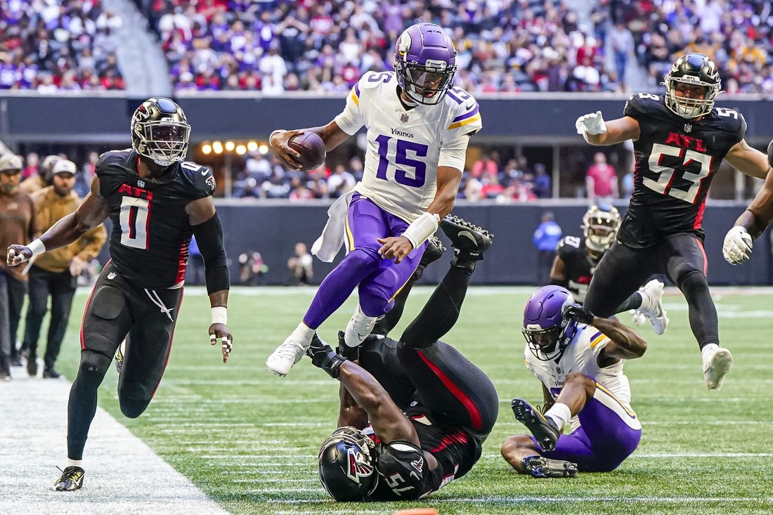 Nov 5, 2023; Atlanta, Georgia, USA; Minnesota Vikings quarterback Joshua Dobbs (15) jumps over Atlanta Falcons defensive tackle Kentavius Street (75) during the second half at Mercedes-Benz Stadium. Mandatory Credit: Dale Zanine-USA TODAY Sports