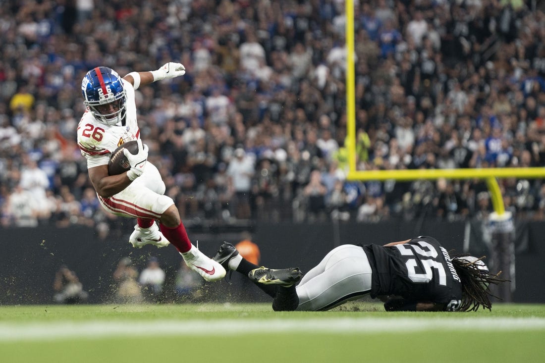 New York Giants running back Saquon Barkley (26) is tackled by Las Vegas Raiders safety Tre'von Moehrig (25) during the third quarter at Allegiant Stadium. Mandatory Credit: Kyle Terada-USA TODAY Sports