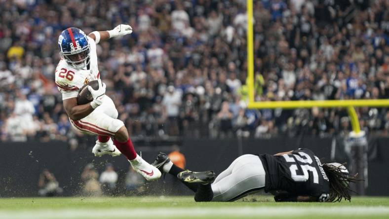 New York Giants running back Saquon Barkley (26) is tackled by Las Vegas Raiders safety Tre'von Moehrig (25) during the third quarter at Allegiant Stadium. Mandatory Credit: Kyle Terada-USA TODAY Sports