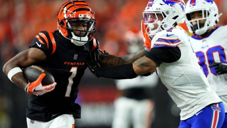 Cincinnati Bengals wide receiver Ja'Marr Chase (1) stiff arms Buffalo Bills cornerback Taron Johnson (7) after a catch in the fourth quarter during a Week 9 NFL football game between the Buffalo Bills and the Cincinnati Bengals, Sunday, Nov. 5, 2023, at Paycor Stadium in Cincinnati.