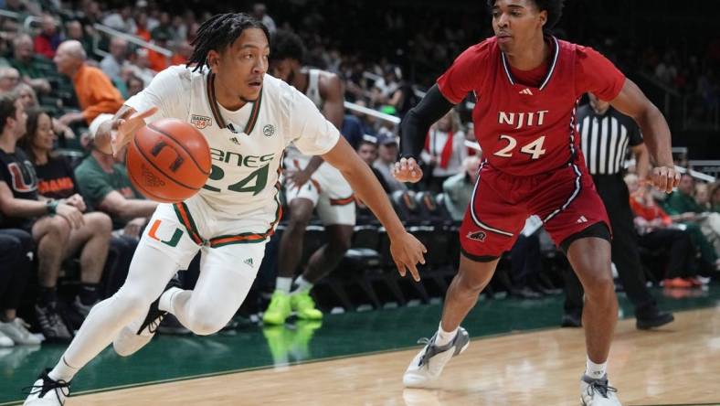 Nov 6, 2023; Coral Gables, Florida, USA; Miami (Fl) Hurricanes guard Nijel Pack (24) drives past N.J.I.T Highlanders guard Mekhi Gray (24) in the first half at Watsco Center. Mandatory Credit: Jim Rassol-USA TODAY Sports