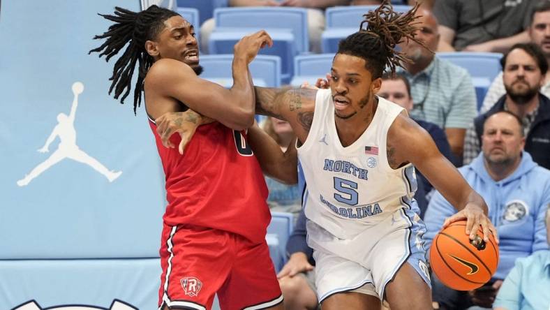 Nov 6, 2023; Chapel Hill, North Carolina, USA;  North Carolina Tar Heels forward Armando Bacot (5) with the ball as Radford Highlanders forward Justin Archer (0) defends in the first half at Dean E. Smith Center. Mandatory Credit: Bob Donnan-USA TODAY Sports