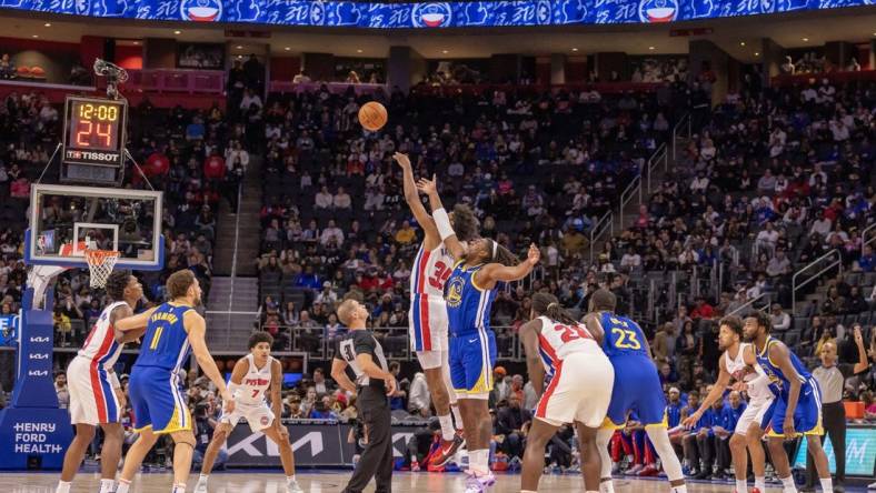 Nov 6, 2023; Detroit, Michigan, USA; Detroit Pistons forward Marvin Bagley III (35) and Golden State Warriors forward Kevon Looney (5) jump for the basketball to start the game at Little Caesars Arena. Mandatory Credit: David Reginek-USA TODAY Sports