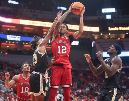 Louisville Cardinals forward JJ Traynor (12) gets fouled by UMBC Retrievers guard Dion Brown (13) Monday night at the Cardinals men's basketball season opener. Nov.6, 2023.