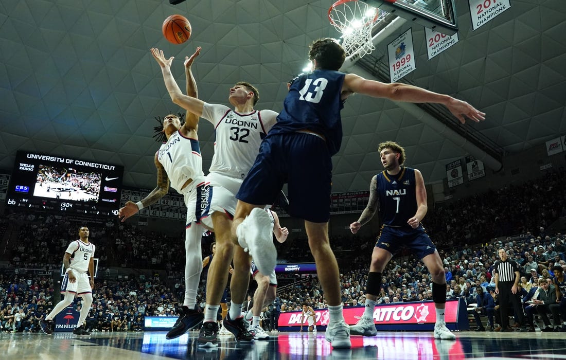 Nov 6, 2023; Storrs, Connecticut, USA; UConn Huskies center Donovan Clingan (32) and guard Solomon Ball (1) defend against Northern Arizona Lumberjacks forward Rockwell Reynolds (13) in the second half at Harry A. Gampel Pavilion. Mandatory Credit: David Butler II-USA TODAY Sports