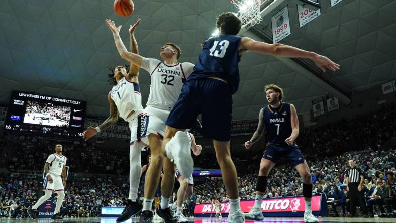 Nov 6, 2023; Storrs, Connecticut, USA; UConn Huskies center Donovan Clingan (32) and guard Solomon Ball (1) defend against Northern Arizona Lumberjacks forward Rockwell Reynolds (13) in the second half at Harry A. Gampel Pavilion. Mandatory Credit: David Butler II-USA TODAY Sports