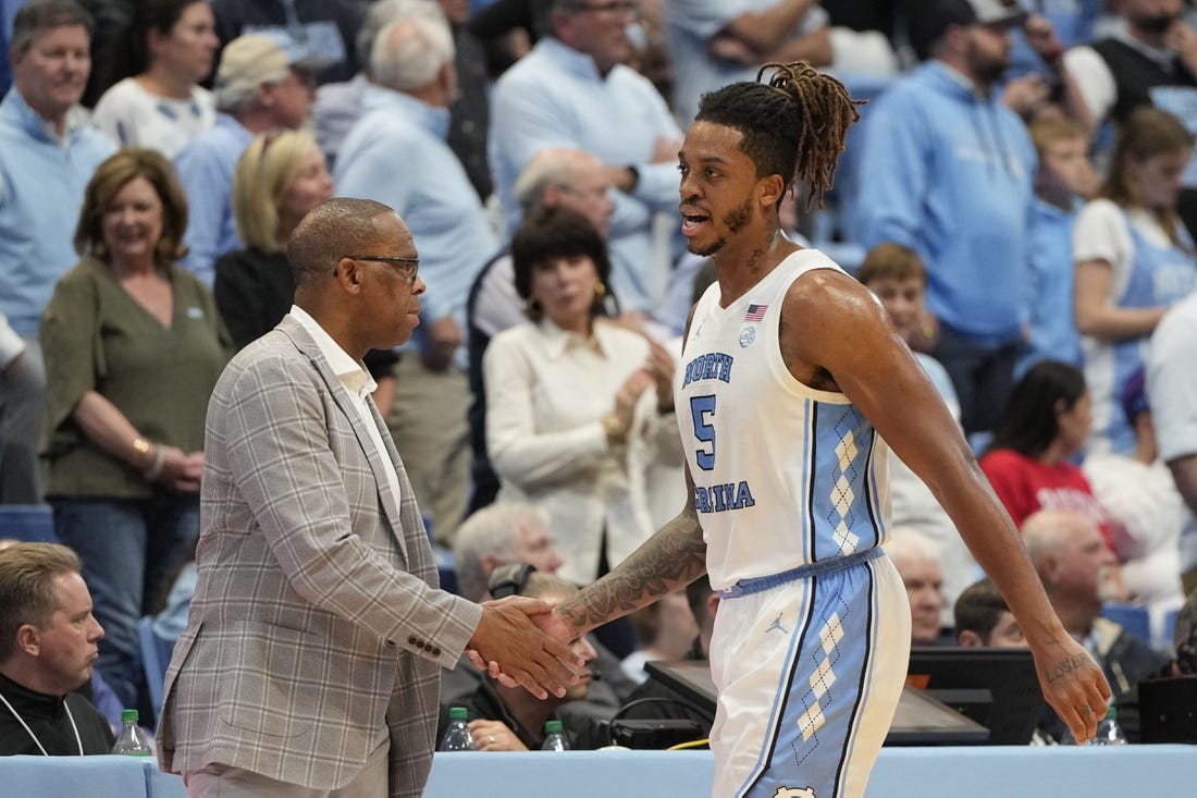 Nov 6, 2023; Chapel Hill, North Carolina, USA; North Carolina Tar Heels forward Armando Bacot (5) shakes hands with head coach Hubert Davis leaving the court in the second half at Dean E. Smith Center. Mandatory Credit: Bob Donnan-USA TODAY Sports