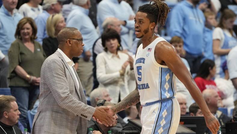 Nov 6, 2023; Chapel Hill, North Carolina, USA; North Carolina Tar Heels forward Armando Bacot (5) shakes hands with head coach Hubert Davis leaving the court in the second half at Dean E. Smith Center. Mandatory Credit: Bob Donnan-USA TODAY Sports