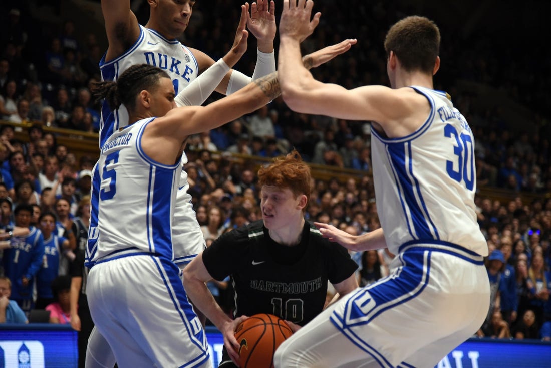 Nov 6, 2023; Durham, North Carolina, USA; Dartmouth Big Green guard Ryan Cornish (10) controls the ball as Duke Blue Devils center Kyle Filipowski(30) and guard Tyrese Proctor(5) defend during the first half at Cameron Indoor Stadium. Mandatory Credit: Rob Kinnan-USA TODAY Sports