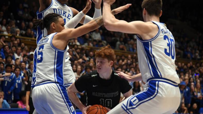 Nov 6, 2023; Durham, North Carolina, USA; Dartmouth Big Green guard Ryan Cornish (10) controls the ball as Duke Blue Devils center Kyle Filipowski(30) and guard Tyrese Proctor(5) defend during the first half at Cameron Indoor Stadium. Mandatory Credit: Rob Kinnan-USA TODAY Sports