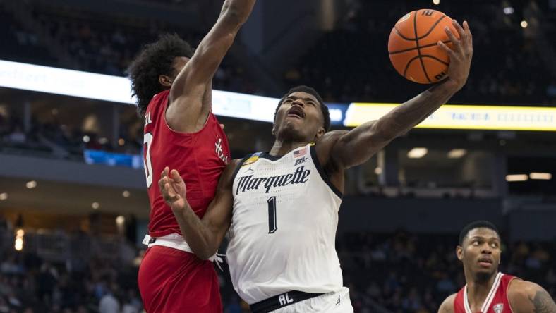 Nov 6, 2023; Milwaukee, Wisconsin, USA;  Marquette Golden Eagles guard Kam Jones (1) shoots against Northern Illinois Huskies guard Zion Russell (10) during the second half at Fiserv Forum. Mandatory Credit: Jeff Hanisch-USA TODAY Sports