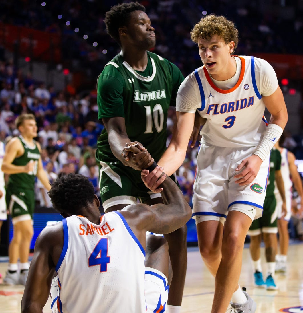 Florida Gators center Micah Handlogten (3) helps teammate Florida Gators forward Tyrese Samuel (4) up off the court. The Florida men   s basketball team hosted the Loyola Greyhounds at Exactech Arena at the Stephen C. O   Connell Center in Gainesville, FL on Monday, November 6, 2023 in the season opener. Gators lead 42-30 at the half. [Doug Engle/Ocala Star Banner]