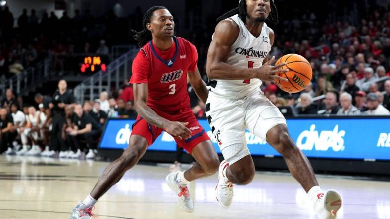 Cincinnati Bearcats guard Day Day Thomas (1) drives to the basket as Illinois-Chicago Flames guard CJ Jones (3) defends in the first half of a men   s college basketball game between the Illinois-Chicago Flames and the Cincinnati Bearcats, Monday, Nov. 6, 2023, at Fifth Third Arena in Cincinnati.