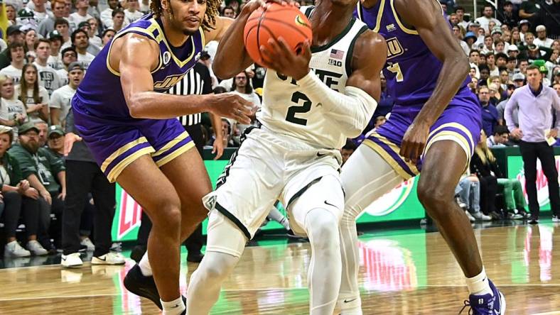 Nov 6, 2023; East Lansing, Michigan, USA; Michigan State Spartans guard Tyson Walker (2) drives through James Madison Dukes forward T.J. Bickerstaff (3) and guard Bryant Randleman (4) during the second half at Jack Breslin Student Events Center. Mandatory Credit: Dale Young-USA TODAY Sports