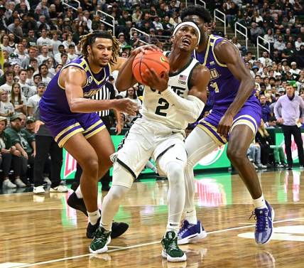 Nov 6, 2023; East Lansing, Michigan, USA; Michigan State Spartans guard Tyson Walker (2) drives through James Madison Dukes forward T.J. Bickerstaff (3) and guard Bryant Randleman (4) during the second half at Jack Breslin Student Events Center. Mandatory Credit: Dale Young-USA TODAY Sports