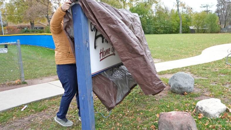 A man who wished to remain unidentified covers up a sign outside Craig Counsell Park on North Lydell Avenue that was vandalized in the last day with spray paint in Whitefish Bay on Tuesday, Nov. 7, 2023. Counsell signed a record-breaking contract to manage the Chicago Cubs.