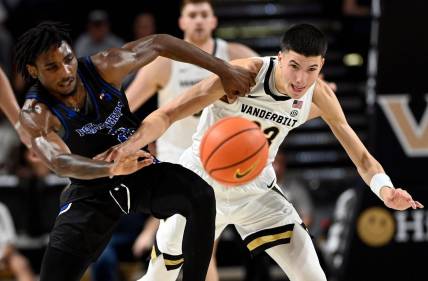 Presbyterian guard Samage Teel, left, and Vanderbilt guard Jason Rivera-Torres (23) battle to get a loose ball during the first half of an NCAA college basketball game Tuesday, Nov. 7, 2023, in Nashville, Tenn.