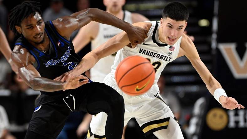 Presbyterian guard Samage Teel, left, and Vanderbilt guard Jason Rivera-Torres (23) battle to get a loose ball during the first half of an NCAA college basketball game Tuesday, Nov. 7, 2023, in Nashville, Tenn.