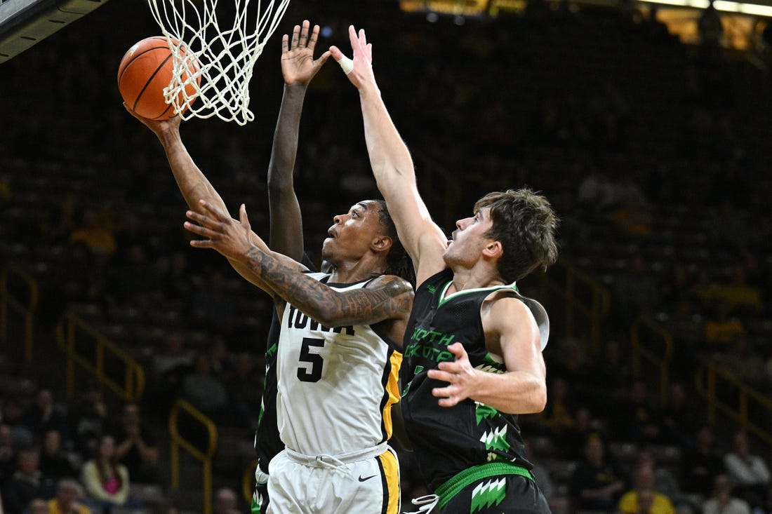 Nov 7, 2023; Iowa City, Iowa, USA; Iowa Hawkeyes guard Dasonte Bowen (5) drives against North Dakota Fighting Hawks forward Amar Kuljuhovic (3) during the first half at Carver-Hawkeye Arena. Mandatory Credit: Jeffrey Becker-USA TODAY Sports