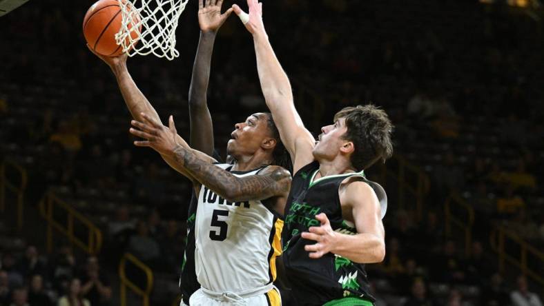 Nov 7, 2023; Iowa City, Iowa, USA; Iowa Hawkeyes guard Dasonte Bowen (5) drives against North Dakota Fighting Hawks forward Amar Kuljuhovic (3) during the first half at Carver-Hawkeye Arena. Mandatory Credit: Jeffrey Becker-USA TODAY Sports