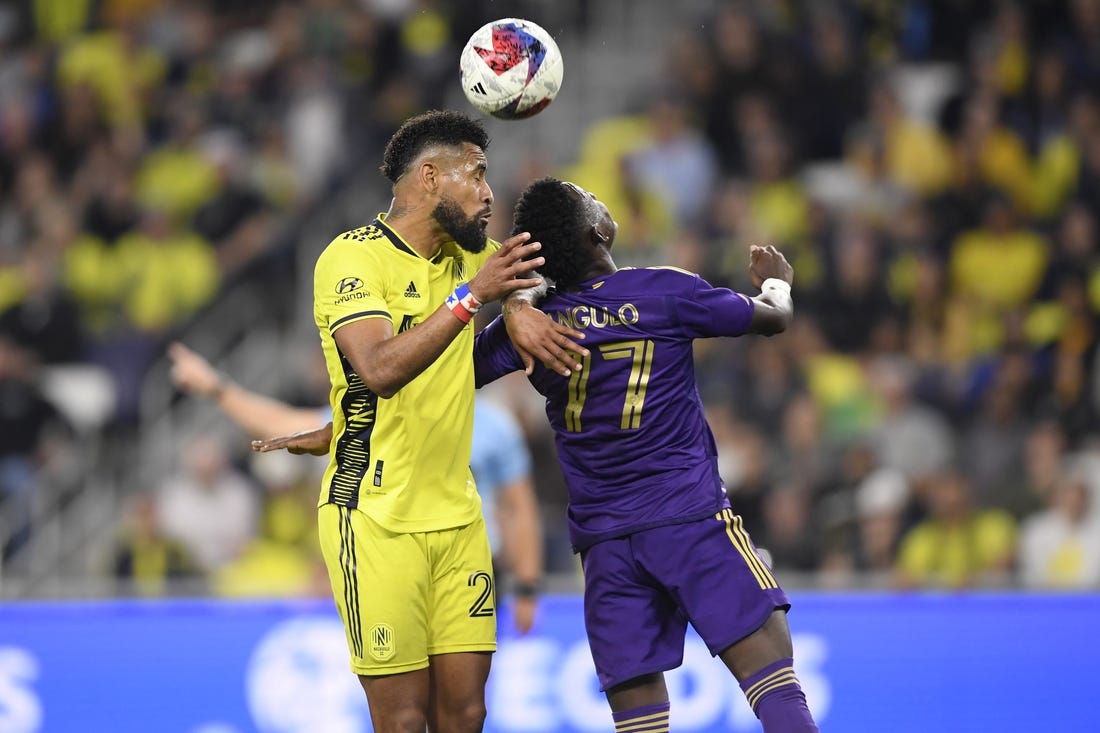 Nov 7, 2023; Nashville, Tennessee, USA; Nashville SC midfielder Anibal Godoy (20) heads the ball against Orlando City forward Ivan Angulo (77) in the second half at Geodis Park. Mandatory Credit: Steve Roberts-USA TODAY Sports