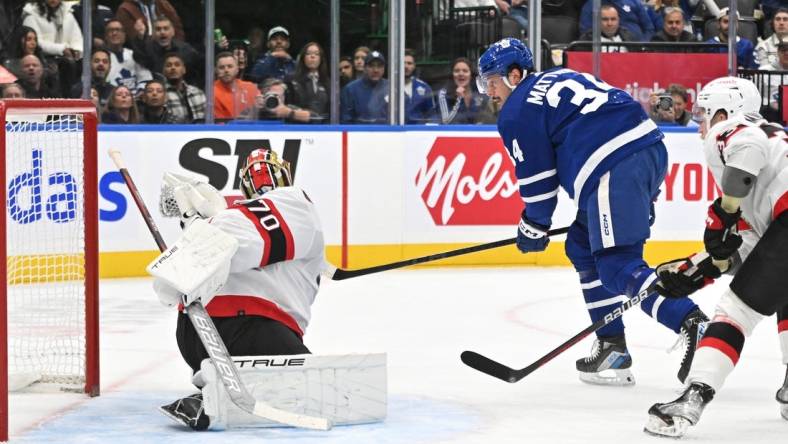 Nov 8, 2023; Toronto, Ontario, CAN; Ottawa Senators goalie Joonas Korpisalo (70) makes a glove save on Toronto Maple Leafs forward Auston Matthews (34) in the first period at Scotiabank Arena. Mandatory Credit: Dan Hamilton-USA TODAY Sports