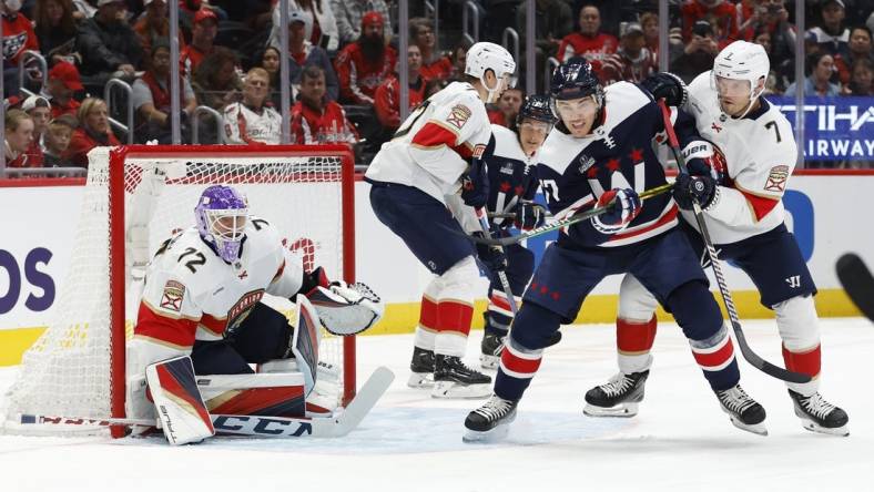 Nov 8, 2023; Washington, District of Columbia, USA; Washington Capitals right wing T.J. Oshie (77) and Florida Panthers defenseman Dmitry Kulikov (7) battle for the puck in front of Panthers goaltender Sergei Bobrovsky (72) in the first period at Capital One Arena. Mandatory Credit: Geoff Burke-USA TODAY Sports