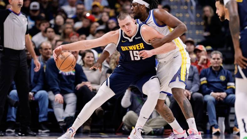 Nov 8, 2023; Denver, Colorado, USA; Denver Nuggets center Nikola Jokic (15) controls the ball under pressure from Golden State Warriors forward Kevon Looney (5) in the first quarter at Ball Arena. Mandatory Credit: Isaiah J. Downing-USA TODAY Sports