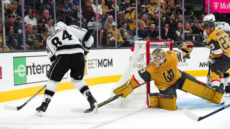 Nov 8, 2023; Las Vegas, Nevada, USA; Vegas Golden Knights goaltender Adin Hill (33) deflects the puck away from Los Angeles Kings defenseman Vladislav Gavrikov (84) during the first period at T-Mobile Arena. Mandatory Credit: Stephen R. Sylvanie-USA TODAY Sports