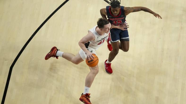 Nov 10, 2023; Cincinnati, Ohio, USA;  Cincinnati Bearcats guard Simas Lukosius (41) drives to the basket against Detroit Mercy Titans guard Marcus Tankersley (35) in the first half at Fifth Third Arena. Mandatory Credit: Aaron Doster-USA TODAY Sports