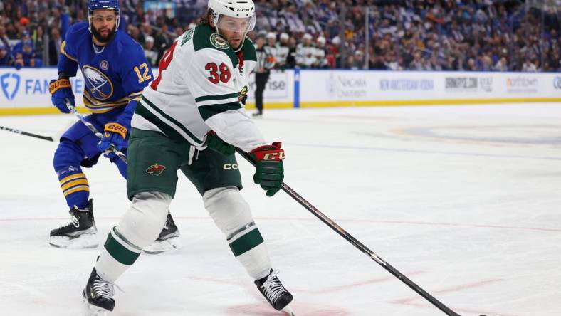 Nov 10, 2023; Buffalo, New York, USA;  Buffalo Sabres left wing Jordan Greenway (12) watches as Minnesota Wild right wing Ryan Hartman (38) drops a pass during the first period at KeyBank Center. Mandatory Credit: Timothy T. Ludwig-USA TODAY Sports