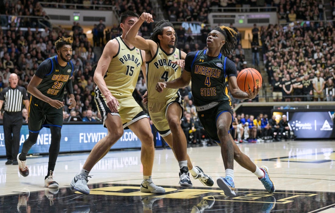 Nov 10, 2023; West Lafayette, Indiana, USA; Morehead State Eagles guard Eddie Ricks III (4) drives toward the basket in front of Purdue Boilermakers forward Trey Kaufman-Renn (4) and center Zach Edey (15) during the first half at Mackey Arena. Mandatory Credit: Marc Lebryk-USA TODAY Sports