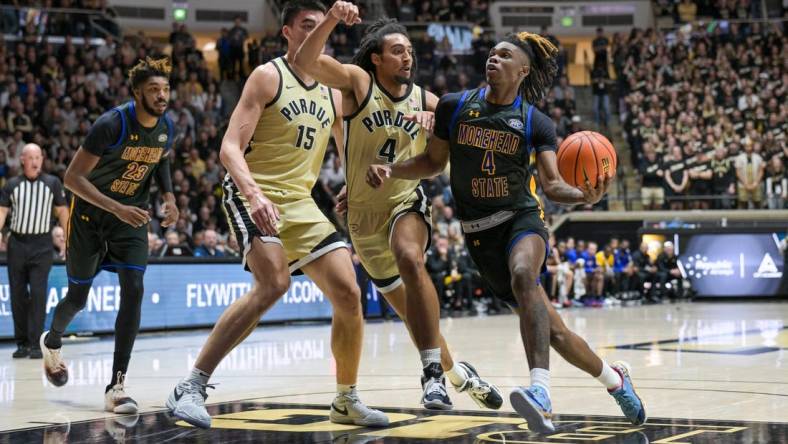 Nov 10, 2023; West Lafayette, Indiana, USA; Morehead State Eagles guard Eddie Ricks III (4) drives toward the basket in front of Purdue Boilermakers forward Trey Kaufman-Renn (4) and center Zach Edey (15) during the first half at Mackey Arena. Mandatory Credit: Marc Lebryk-USA TODAY Sports