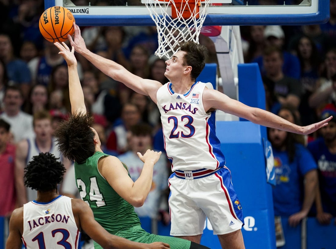 Nov 10, 2023; Lawrence, Kansas, USA; Kansas Jayhawks forward Parker Braun (23) blocks the shot of Manhattan Jaspers forward Xinyi Li (24) during the first half at Allen Fieldhouse. Mandatory Credit: Jay Biggerstaff-USA TODAY Sports