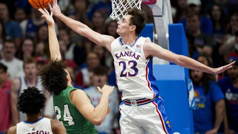 Nov 10, 2023; Lawrence, Kansas, USA; Kansas Jayhawks forward Parker Braun (23) blocks the shot of Manhattan Jaspers forward Xinyi Li (24) during the first half at Allen Fieldhouse. Mandatory Credit: Jay Biggerstaff-USA TODAY Sports