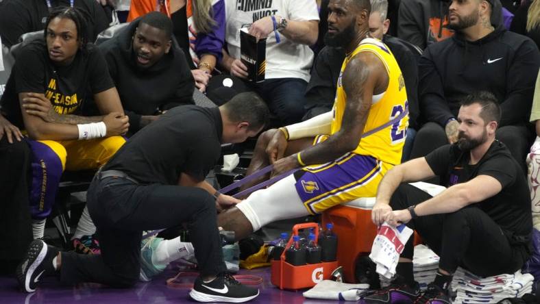 Nov 10, 2023; Phoenix, Arizona, USA; Los Angeles Lakers forward LeBron James (23) gets medical attention in a timeout against the Phoenix Suns in the first half at Footprint Center. Mandatory Credit: Rick Scuteri-USA TODAY Sports