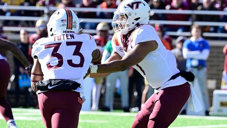 Nov 11, 2023; Chestnut Hill, Massachusetts, USA; Virginia Tech Hokies quarterback Kyron Drones (1) hands the ball to running back Bhayshul Tuten (33) during the first half against the Boston College Eagles at Alumni Stadium. Mandatory Credit: Eric Canha-USA TODAY Sports