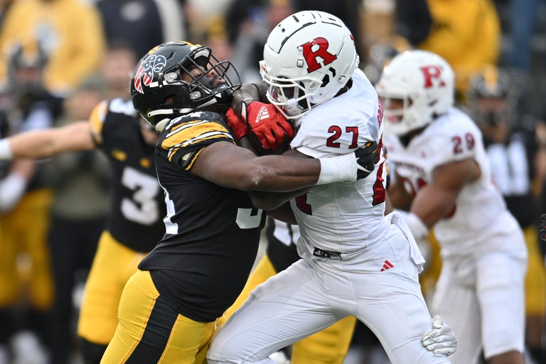 Nov 11, 2023; Iowa City, Iowa, USA; Iowa Hawkeyes linebacker Jay Higgins (34) tackles Rutgers Scarlet Knights running back Samuel Brown V (27) during the second quarter at Kinnick Stadium. Mandatory Credit: Jeffrey Becker-USA TODAY Sports