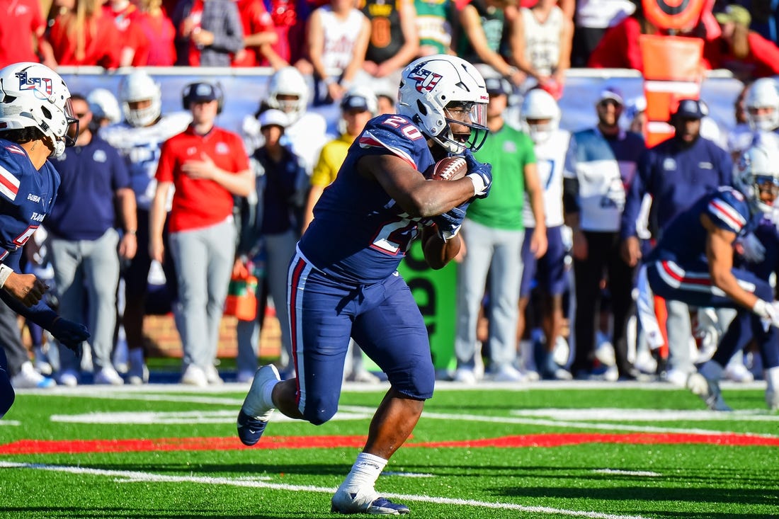 Nov 11, 2023; Lynchburg, Virginia, USA;  Liberty Flames running back Quinton Cooley (20) runs the ball in the third quarter at Williams Stadium. Mandatory Credit: Brian Bishop-USA TODAY Sports