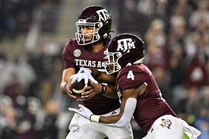 Nov 11, 2023; College Station, Texas, USA; Texas A&M Aggies quarterback Jaylen Henderson (16) hands off the ball to running back Amari Daniels (4) during the first quarter at Kyle Field. Mandatory Credit: Maria Lysaker-USA TODAY Sports