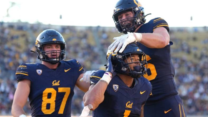 Nov 11, 2023; Berkeley, California, USA; California Golden Bears running back Jaydn Ott (1) gestures towards the Washington State Cougars fan section after scoring a touchdown while being congratulated by tight end Jeffrey Johnson (right) and tight end Jack Endries (87) during the fourth quarter at California Memorial Stadium. Mandatory Credit: Darren Yamashita-USA TODAY Sports