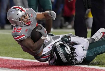 Nov. 11, 2023; Columbus, Oh., USA; 
Ohio State Buckeyes running back TreVeyon Henderson (32) dives into the endzone (32) while he is tackled by Michigan State Spartans defensive back Angelo Grose (15) to score a touchdown during the first half of Saturday's NCAA Division I football game at Ohio Stadium.