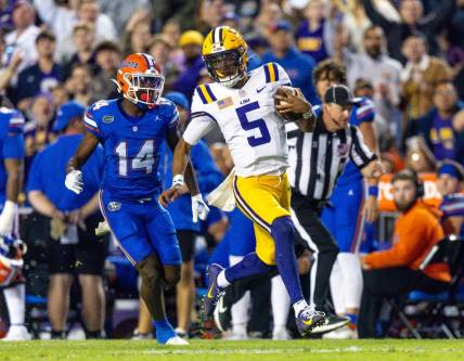 Nov 11, 2023; Baton Rouge, Louisiana, USA;  LSU Tigers quarterback Jayden Daniels (5) rushes for a touchdown against Florida Gators safety Jordan Castell (14) during the first half at Tiger Stadium. Mandatory Credit: Stephen Lew-USA TODAY Sports