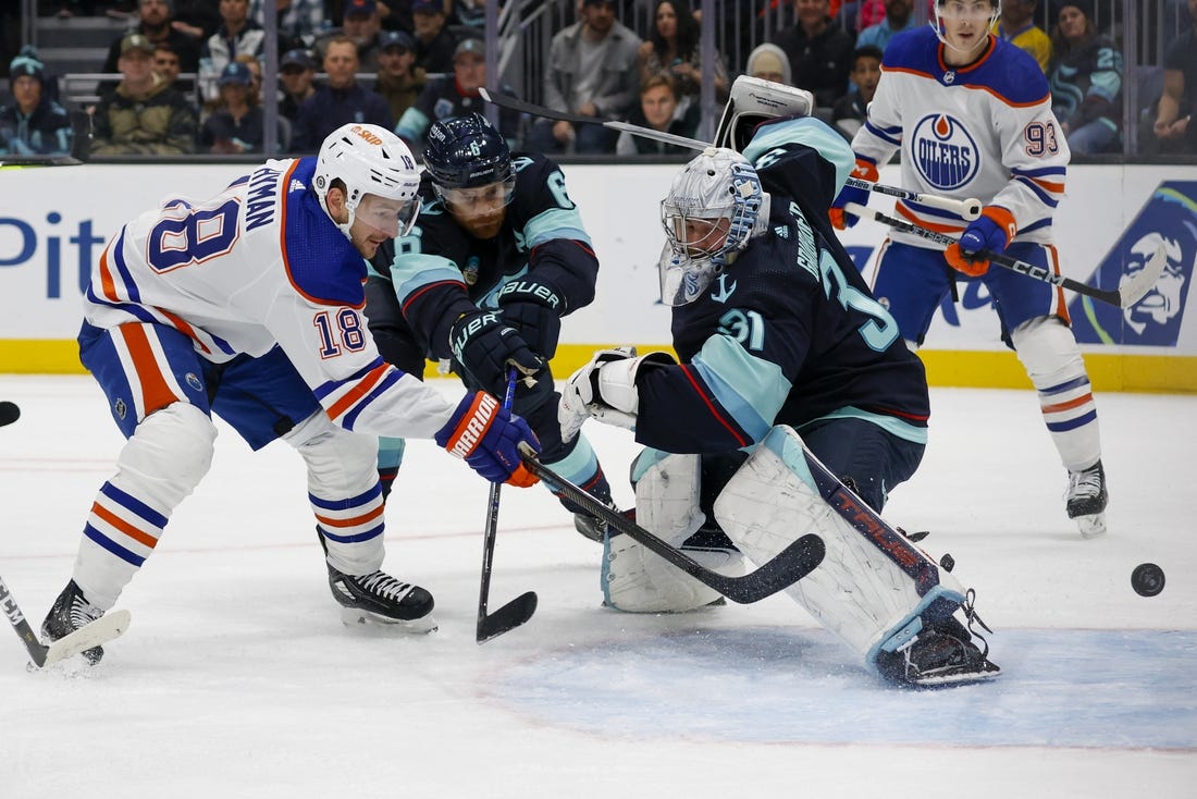 Nov 11, 2023; Seattle, Washington, USA; Edmonton Oilers left wing Zach Hyman (18) scores his second goal of the during the first period against Seattle Kraken goaltender Philipp Grubauer (31) and defenseman Adam Larsson (6)  at Climate Pledge Arena. Mandatory Credit: Joe Nicholson-USA TODAY Sports